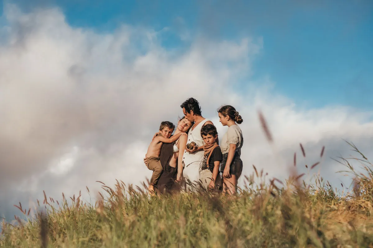 Family standing on a hilltop silhouetted against the sky