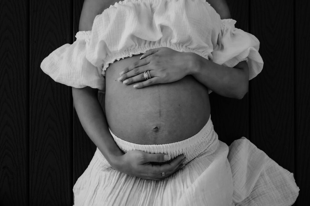 Black and white photo of a pregnant belly during a Boston Maternity Photoshoot
