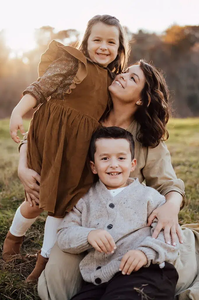 Mom looking up at her smiling daughter while embracing her son by south shore family photographer Caryn scanlan