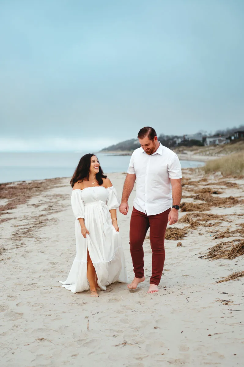 The best Maternity Photo Locations on Cape Cod feel like you're in a world of your own- couple walking alone on the beach in Cape Cod