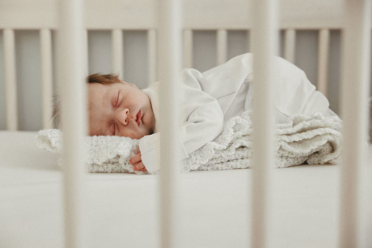 Boston + Cape Cod Newborn Photographer photo of a newborn baby sleeping in his crib by Caryn Scanlan