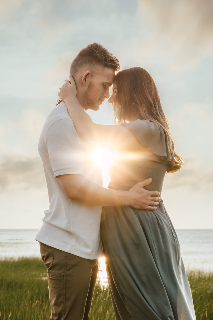 Boston + Cape Cod maternity photography photo of a pregnant woman and her husband hugging with the sun behind them