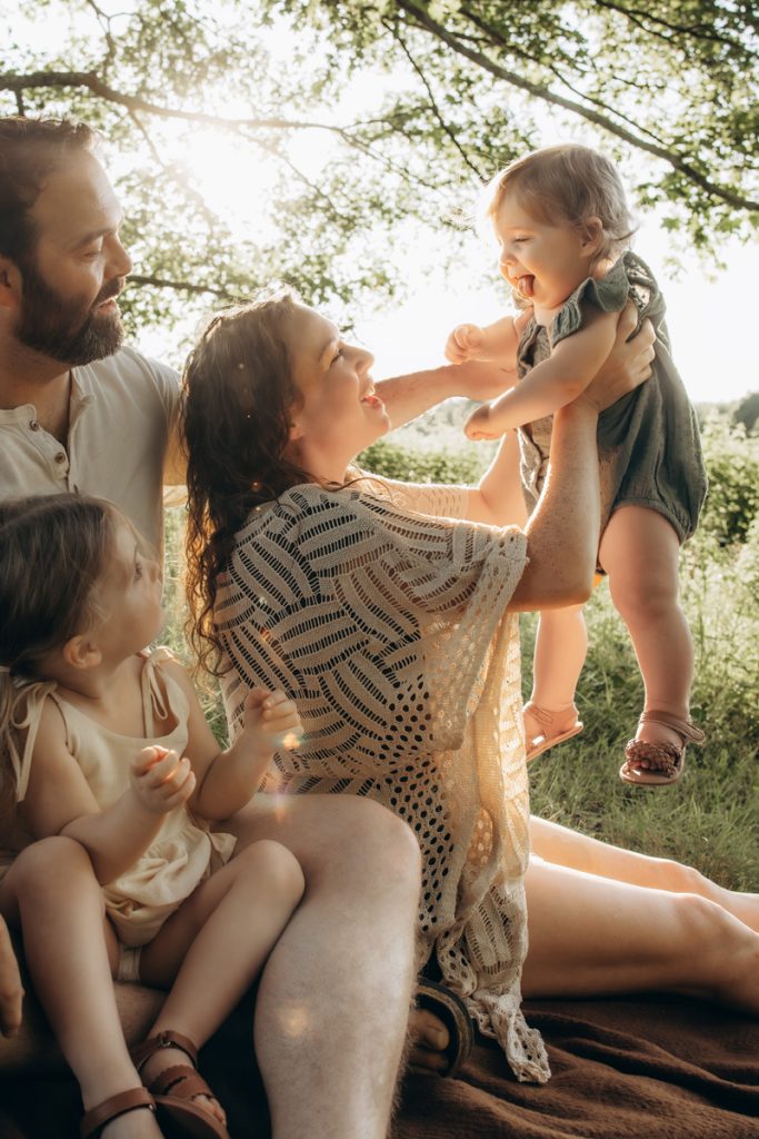 Candid moment between mother and daughters during first birthday shoot in Duxbury MA