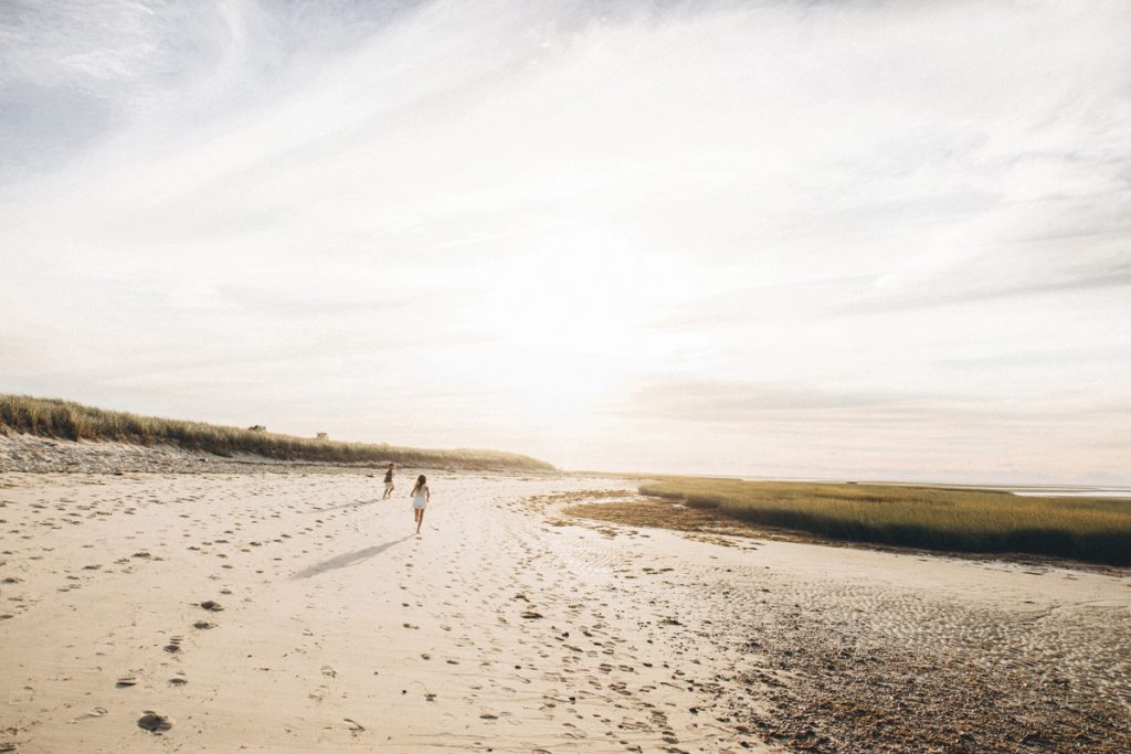 Kids running along the shoreline during their Cape Cod vacation family photos