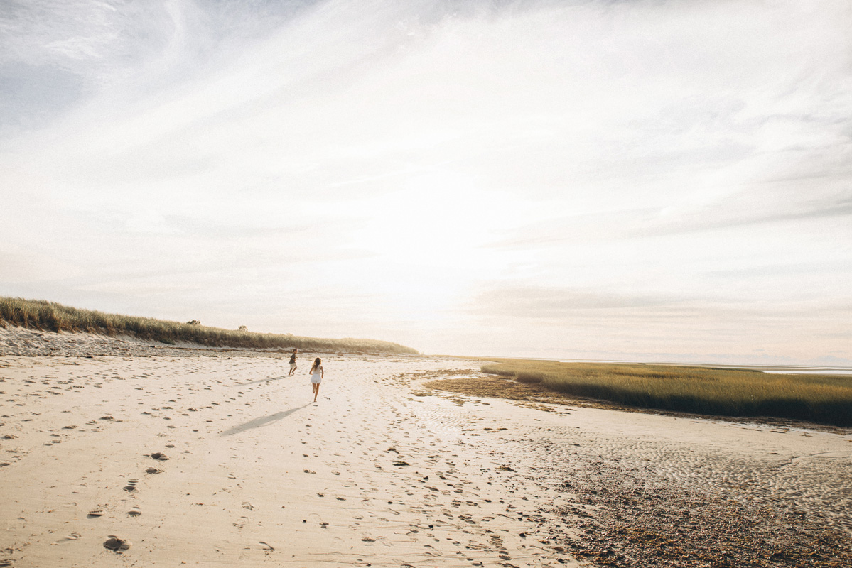 Kids running along the shoreline during their Cape Cod vacation family photos