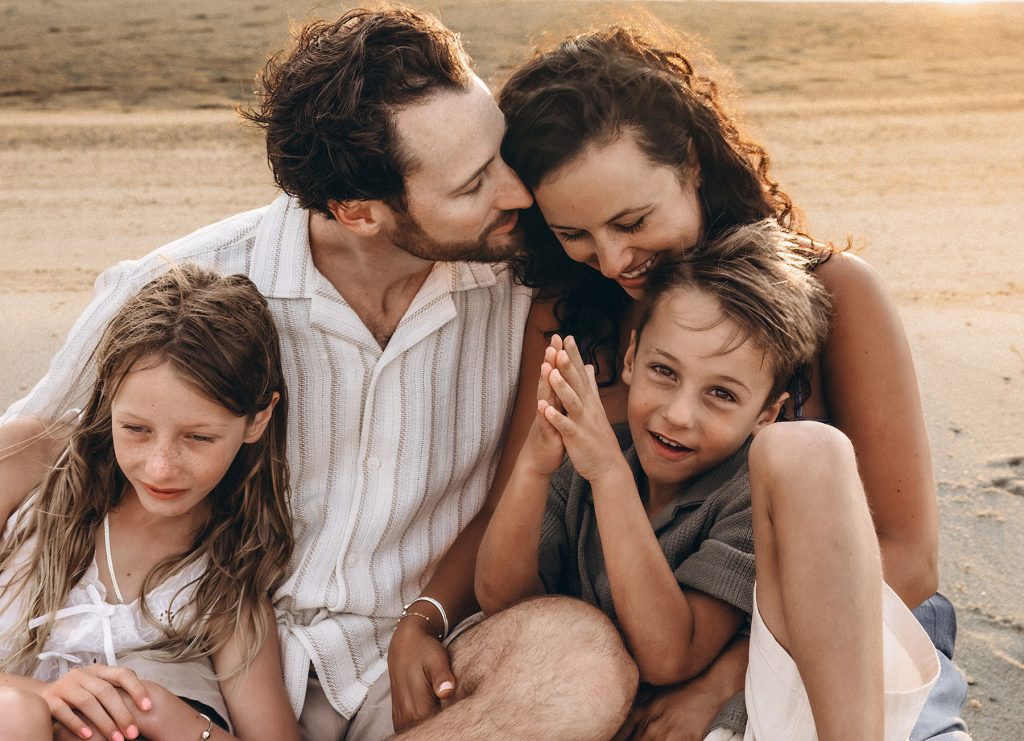 Cape Cod vacation family photos of a family cuddling while seated on the beach