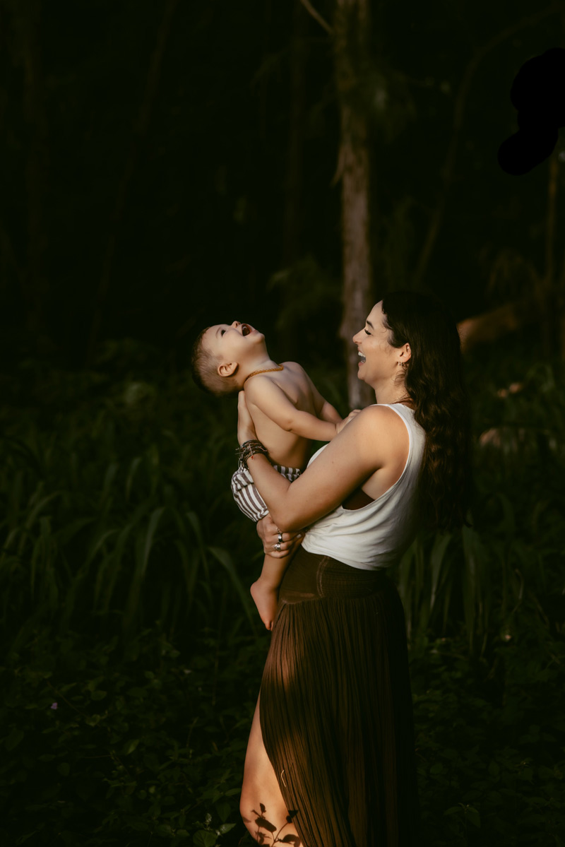 Mom playing with her laughing son under some trees near the beach by Cape Cod Family Photographer