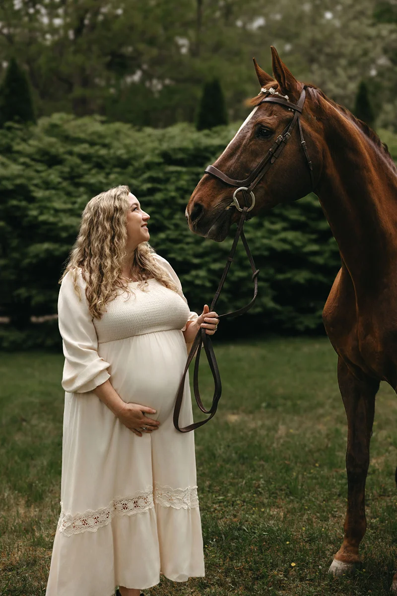 Brewster Maternity photographer photo of a pregnant mama with her horse in a garden