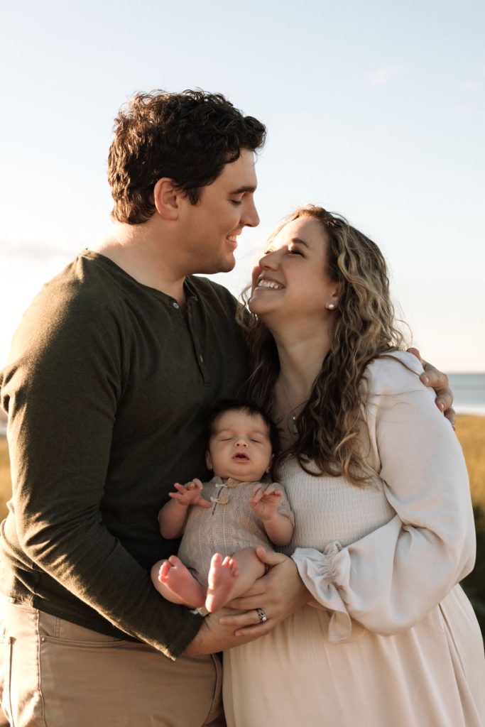 Brewster MA Newborn Beach Session | Brianna, Tyler & Baby Graham 5 Brewster MA Newborn Beach Session photo of a family with their newborn and mom and dad smiling at each other