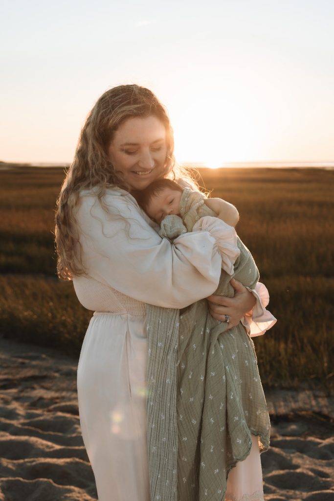Brewster MA Newborn Beach Session | Brianna, Tyler & Baby Graham 43 Mother holding baby at sunset in Brewster on Cape Cod by Caryn Scanlan Photography