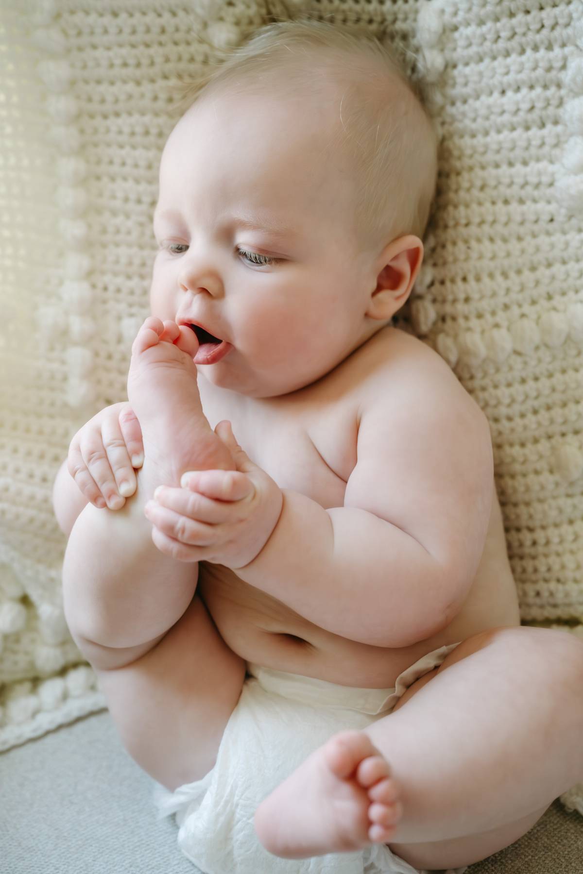6 month old baby session on the South Shore MA trying to eat his toe